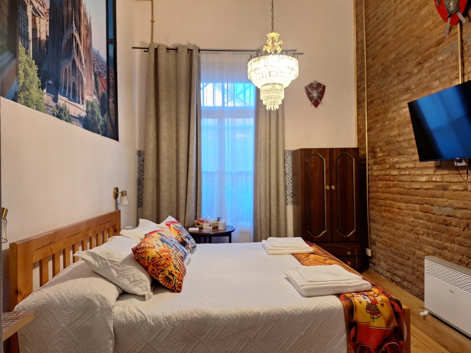 Vista general con cama, ventana y pared de ladrillo en la habitación España de CasaFran